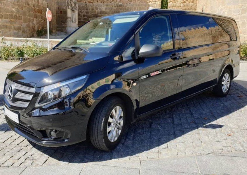 Taxi Madrid Airport (Minivan) - Welcome Pickups Side view of a black Madrid Airport taxi minivan, parked outside.