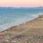 Hundreds of lounge chairs lined up in perfect rows on Rimini Beach looking out over the flat ocean.