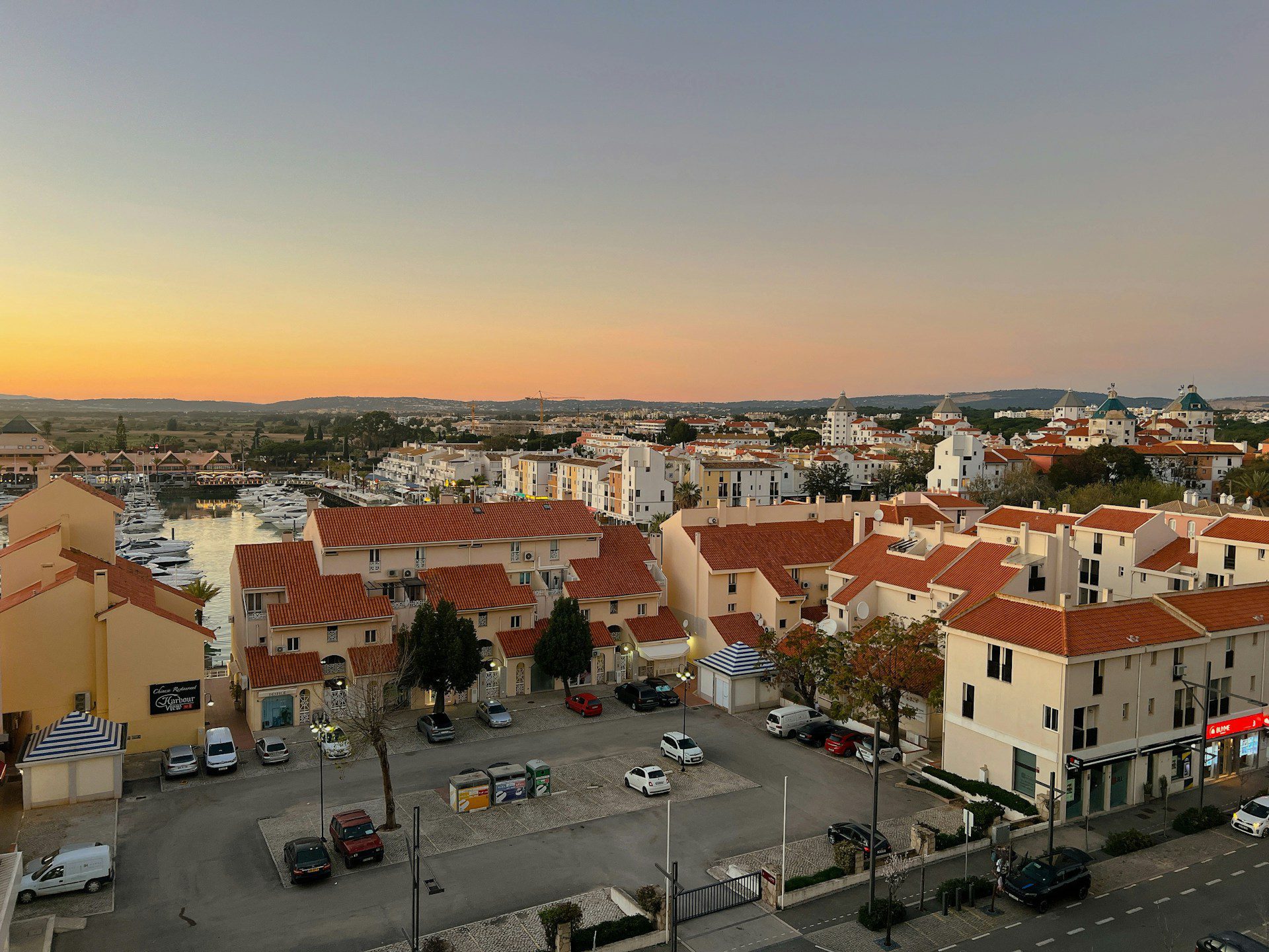 View of Faro town, showing terracotta roofs in the foreground and the sea in the background.