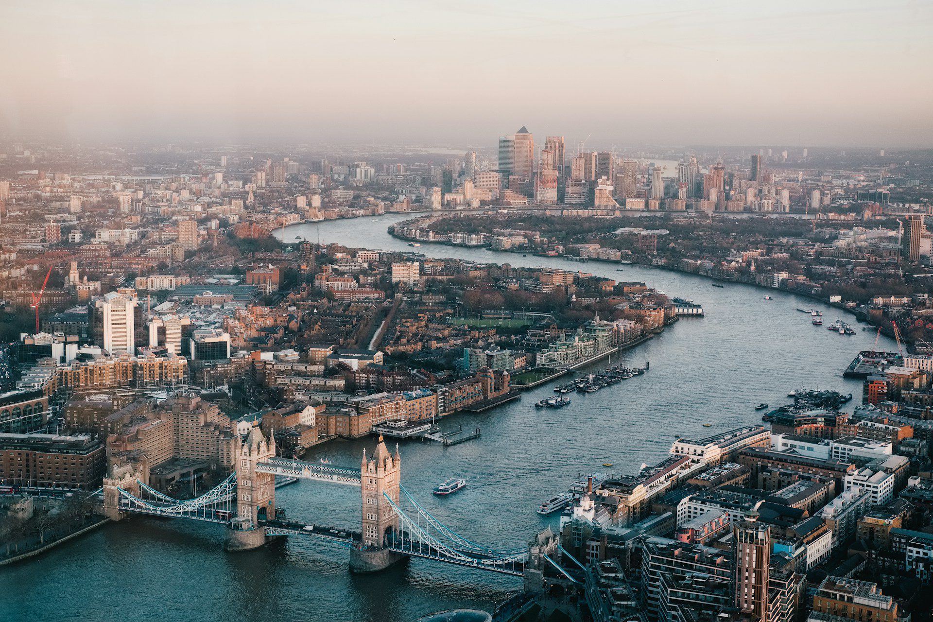 Aerial view of the city of London, with the River Thames and Tower Bridge in the center.