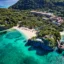 An aerial view of one of the beaches on Boracay Island with a tree-filled headland surrounded by beautiful turquoise water.