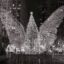 A black and white image of a glass sculpture of a huge Christmas tree with wings.