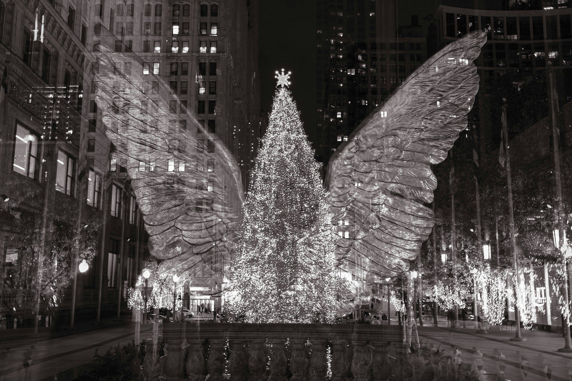 A black and white image of a glass sculpture of a huge Christmas tree with wings.
