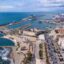 Aerial view of Civitavecchia Port, with a large body of water to the left, and a cruise ship in port.