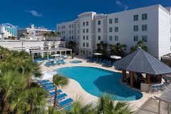 A view of the Hampton Inn and Suites near San Juan Airport with a large pool and beach chairs.