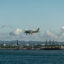a plane is almost landing on a runway in front of blue terrain