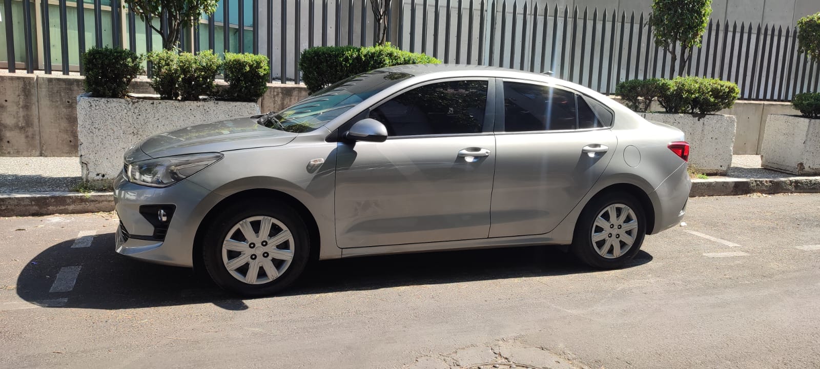 Cancun Airport Taxi Sedan - Welcome Pickups A silver Cancun Airport taxi sedan parked on the side of a sunny street, featuring four doors, tinted windows, and compact styling; commonly used for private airport transfers from Cancun Airport.