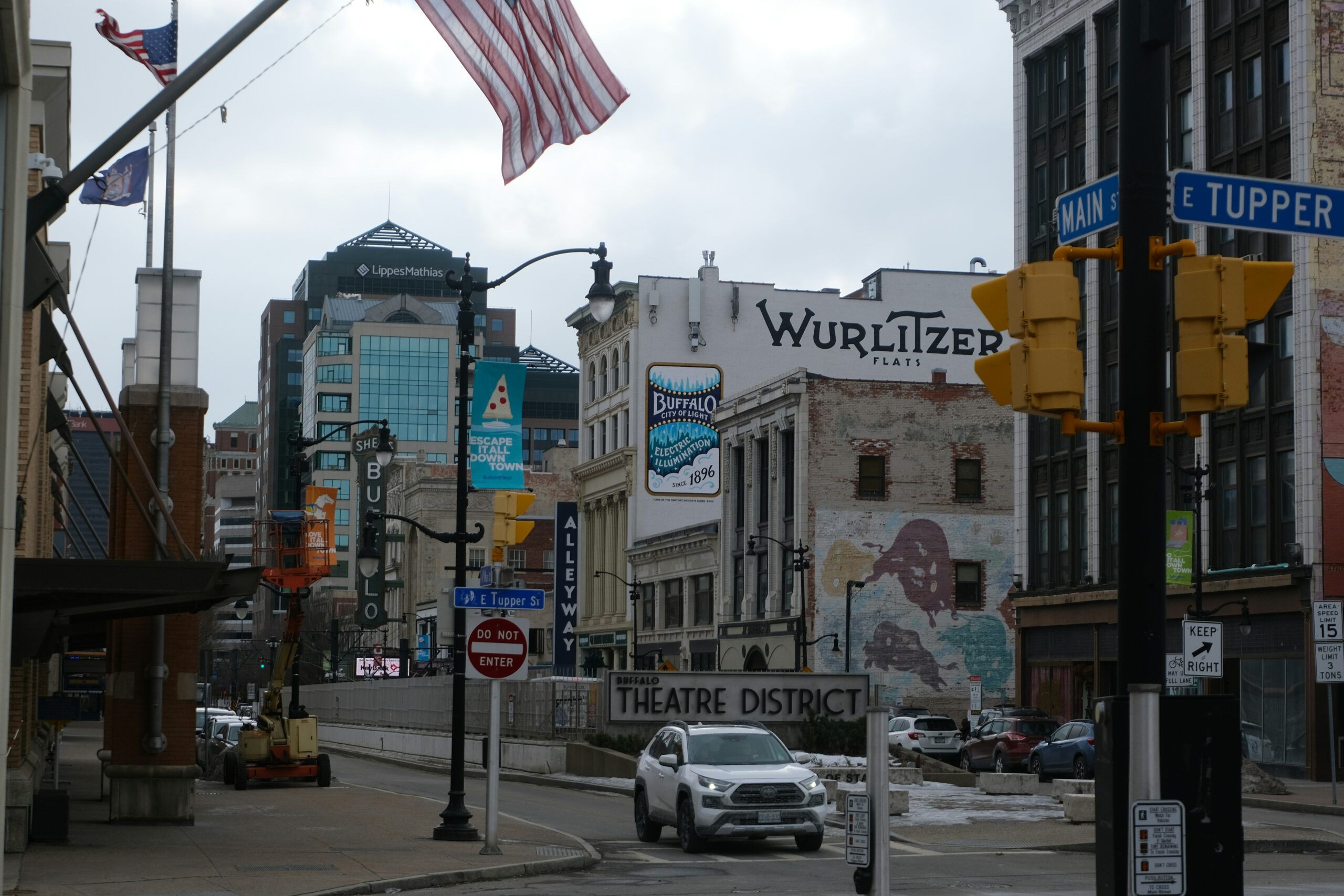 street of Buffalo with cars and an American flag overhead