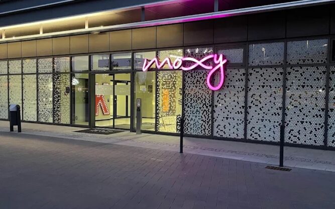 The Moxy Hotel at Cologne Airport with a pink sign