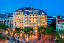 Majestic hotel and spa at night, all windows are lit up giving a warm glow. 