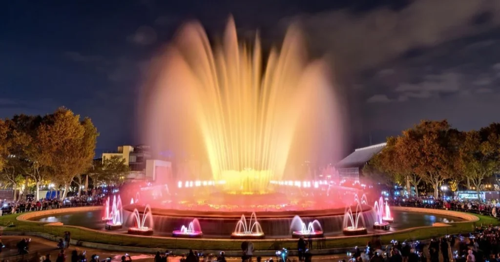 A colourful fountain at night shooting water into the air. 