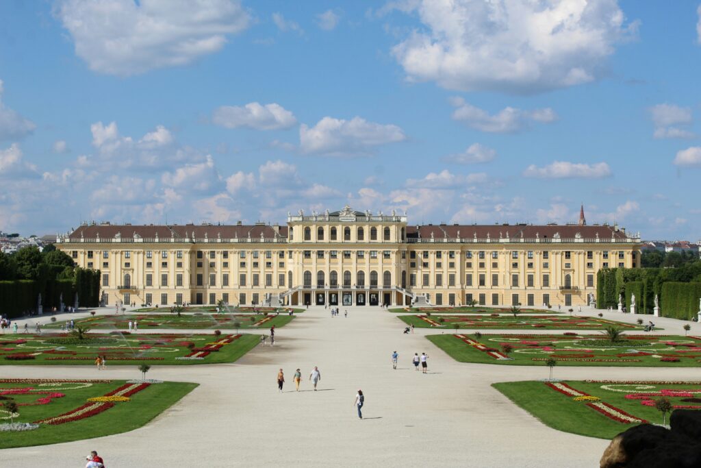A huge concourse flanked by manicured gardens on each side leading up to a palace