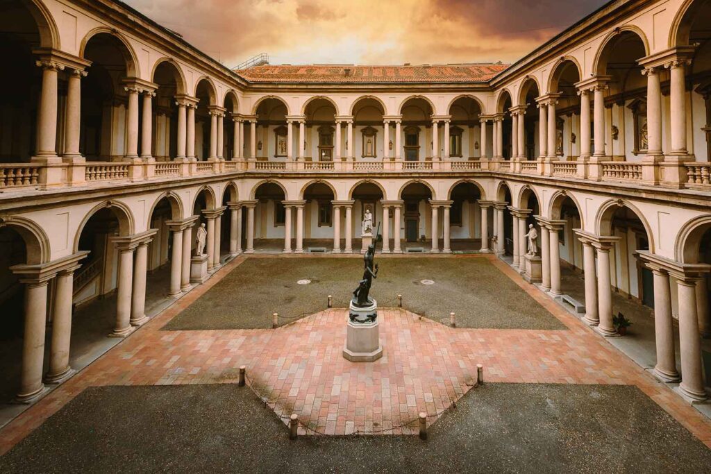 The neoclassical courtyard of Pinacoteca di Brera in Milan, Italy; a sophisticated cultural landmark featured in our Devil Wears Prada 2 travel guide.