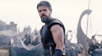 Matt Damon as Odysseus in battle-worn armor, looking back in a dramatic scene from Christopher Nolan's 2026 epic film, The Odyssey.
